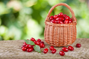 Kızılcık berry sepet bulanık bir bahçe arka plan ile ahşap masa üzerinde yaprak ile
