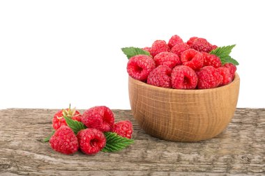 Beyaz arka plan ile masada ahşap bir kabın içinde ahududu