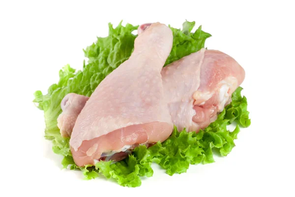 Two raw chicken drumsticks with lettuce leaf isolated on white background Royalty Free Stock Photos