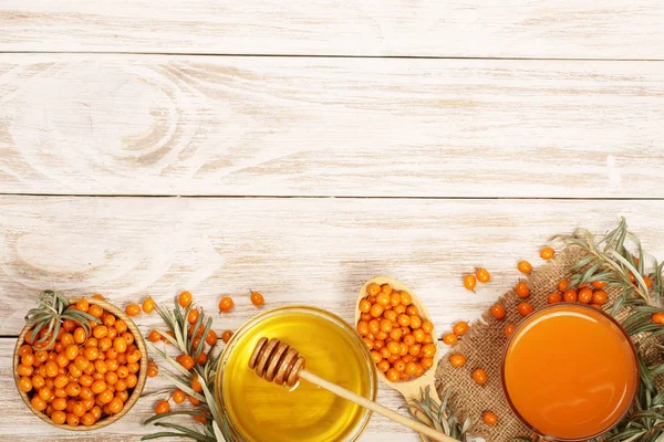 Deniz cehri suyu veya kopya alanı metniniz için beyaz bir ahşap zemin üzerine ballı çayı. Üstten Görünüm