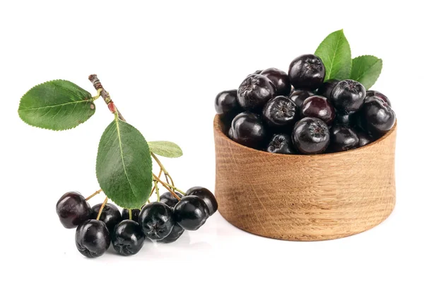 Chokeberry com folha em tigela de madeira isolada em fundo branco. Bagas de aronia preta — Fotografia de Stock