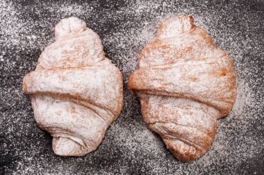 iki ay çöreği siyah taş arka plan üzerine pudra şekeri serpilir. Üstten Görünüm