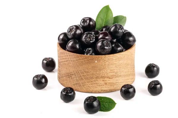 Chokeberry with leaf in wooden bowl isolated on white background. Black aronia berries — Stock Photo, Image