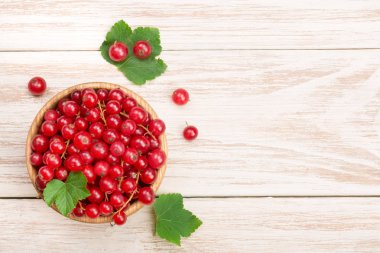 Frenk üzümü çilek yaprak metniniz için kopya alanı ile ışık ahşap arka plan üzerinde ahşap bir kase. Üstten Görünüm