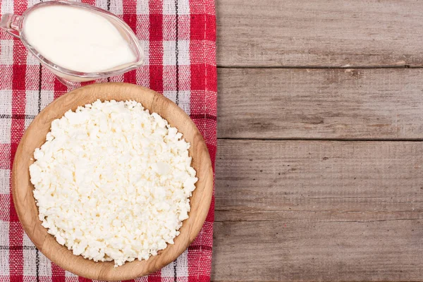 Ekşi krema kopya alanı metniniz için eski ahşap zemin üzerine ahşap bir kase süzme peynir. Üstten Görünüm