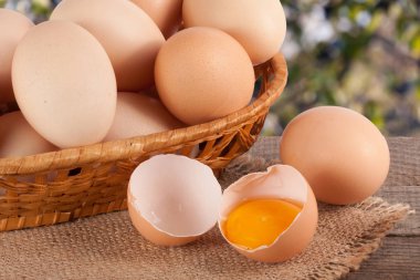 Bahçe arka plan bulanık ile ahşap bir gemide bir hasır sepet yumurta