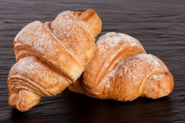 iki ay çöreği siyah taş arka plan üzerine pudra şekeri serpilir