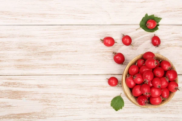 Hawthorn berry s listy v misce na bílém pozadí dřevěná kopie prostor pro váš text. Pohled shora — Stock fotografie