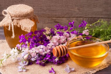 Kavanoz bal ile kır çiçekleri koyu ahşap arka plan üzerinde