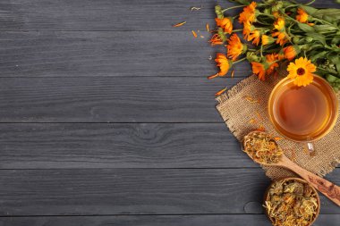 Taze ve kurutulmuş çiçekler, metniniz için kopya alanı siyah ahşap zemin üzerine Calendula çay. Üstten Görünüm