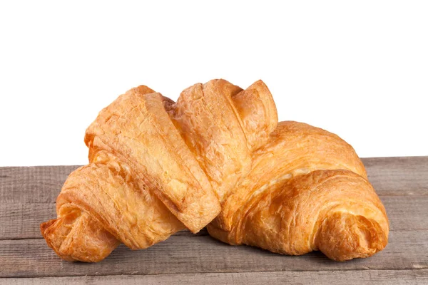 Dois croissant em uma mesa de madeira com fundo branco — Fotografia de Stock