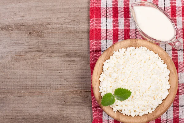 Ekşi krema kopya alanı metniniz için eski ahşap zemin üzerine ahşap bir kase süzme peynir. Üstten Görünüm