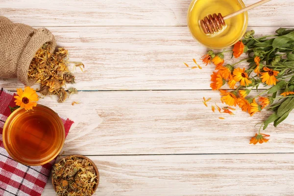 Taze ve kurutulmuş çiçekler, metniniz için kopya alanı Beyaz ahşap zemin üzerine Calendula çay. Üstten Görünüm