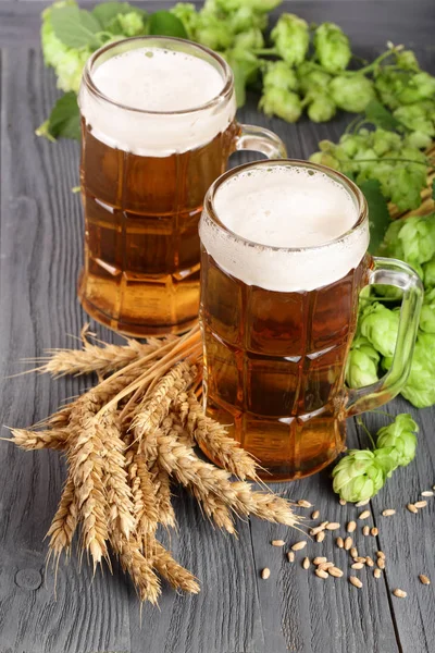 bardak köpüklü bira hop koniler ve buğday siyah ahşap zemin üzerine