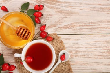çay rose hips ve ballı kopya alanı metniniz için beyaz bir ahşap zemin üzerine. Üstten Görünüm