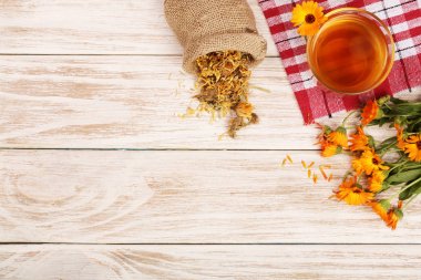 Taze ve kurutulmuş çiçekler, metniniz için kopya alanı Beyaz ahşap zemin üzerine Calendula çay. Üstten Görünüm