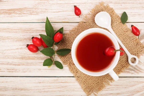 rose hips Beyaz ahşap zemin üzerinde çay. Üstten Görünüm