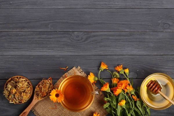Taze ve kurutulmuş çiçekler, metniniz için kopya alanı siyah ahşap zemin üzerine Calendula çay. Üstten Görünüm