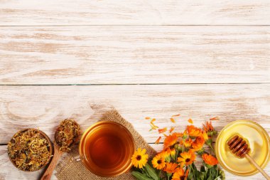 Taze ve kurutulmuş çiçekler, metniniz için kopya alanı Beyaz ahşap zemin üzerine Calendula çay. Üstten Görünüm