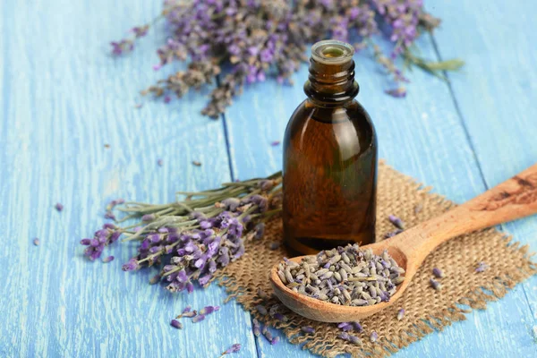 Óleo de ervas e flores de lavanda em fundo de madeira — Fotografia de Stock