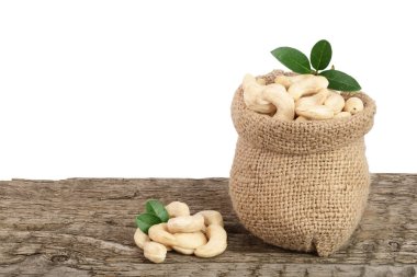 kaju fıstığı çanta beyaz arka plan ile ahşap masa üzerinde yaprak ile