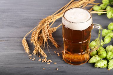 bardak köpüklü bira hop koniler ve buğday siyah ahşap zemin üzerine