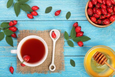 çay rose hips ve ballı mavi ahşap zemin üzerinde. Üstten Görünüm