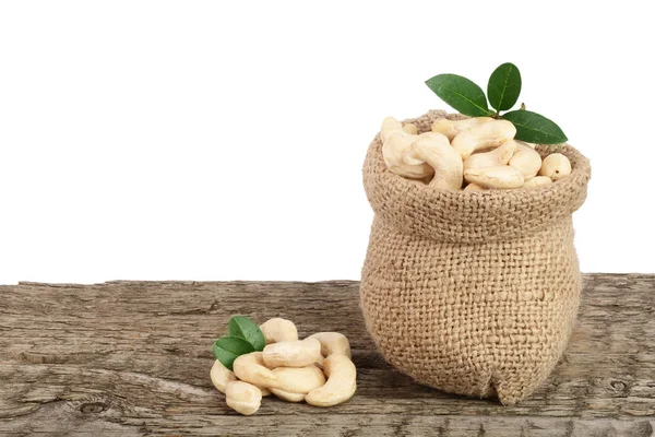 kaju fıstığı çanta beyaz arka plan ile ahşap masa üzerinde yaprak ile