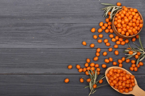 Deniz topalak. Kopya alanı metni siyah ahşap zemin üzerine kabın içinde olgunlaşmış taze çilek. Üstten Görünüm