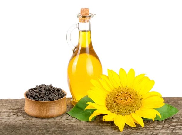 Olej słonecznikowy, nasion i kwiatów na drewniany stół z białym tłem — Zdjęcie stockowe
