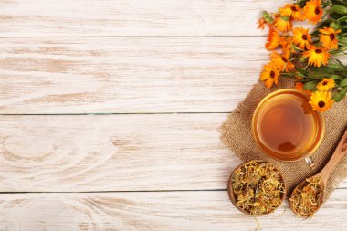 Taze ve kurutulmuş çiçekler, metniniz için kopya alanı Beyaz ahşap zemin üzerine Calendula çay. Üstten Görünüm