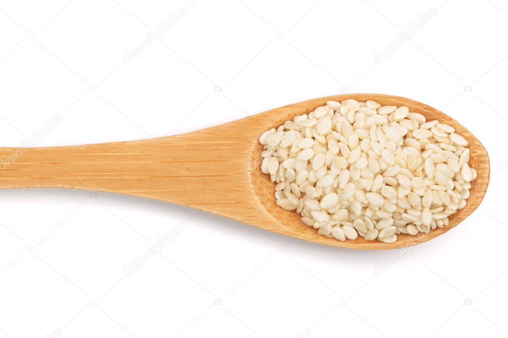 Sesame seeds in a wooden spoon isolated on white background top view