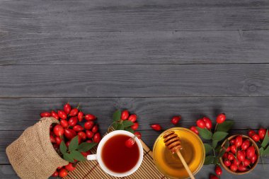 çay rose hips ve ballı kopya alanı metni siyah bir ahşap zemin üzerinde. Üstten Görünüm