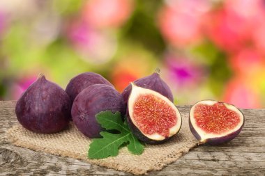 Bahçe arka plan bulanık ile eski ahşap tahta üzerinde yapraklar incir meyve