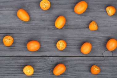 Mandalina veya Kamkat yarısı bllack ahşap arka plan ile. Üstten Görünüm. Düz yatıyordu desen