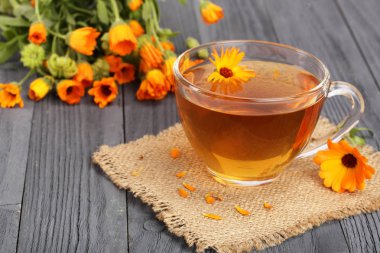 Calendula çay siyah ahşap zemin üzerine taze çiçekler ile