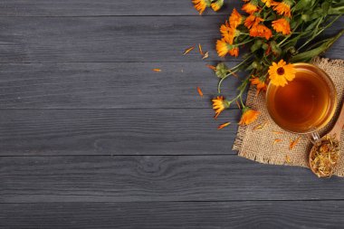 Taze ve kurutulmuş çiçekler, metniniz için kopya alanı siyah ahşap zemin üzerine Calendula çay. Üstten Görünüm