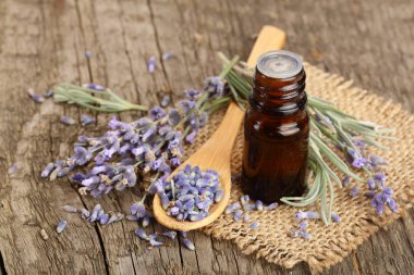Bitkisel yağ ve lavanta çiçekleri eski ahşap arka plan üzerinde