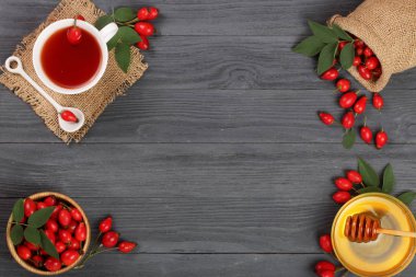 çay rose hips ve ballı kopya alanı metni siyah bir ahşap zemin üzerinde. Üstten Görünüm