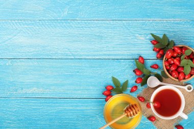 çay rose hips ve ballı kopya alanı metni mavi ahşap zemin üzerine. Üstten Görünüm