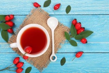 rose hips mavi ahşap zemin üzerine çay. Üstten Görünüm