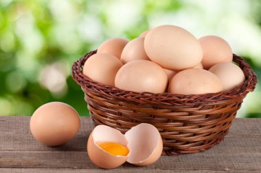 Bahçe arka plan bulanık ile ahşap bir gemide bir hasır sepet yumurta