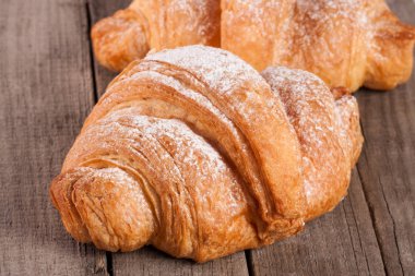 eski ahşap tahta üzerinde pudra şekeri serpilir kruvasan