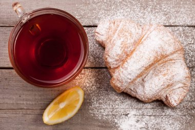 kruvasan ile çay eski ahşap zemin üzerinde. Üstten Görünüm