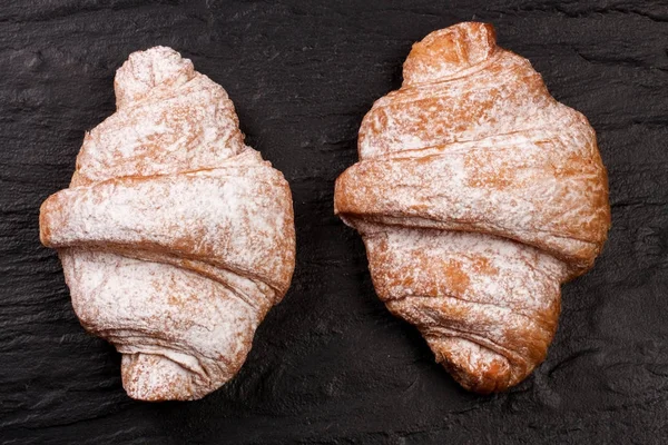 iki ay çöreği siyah taş arka plan üzerine pudra şekeri serpilir. Üstten Görünüm