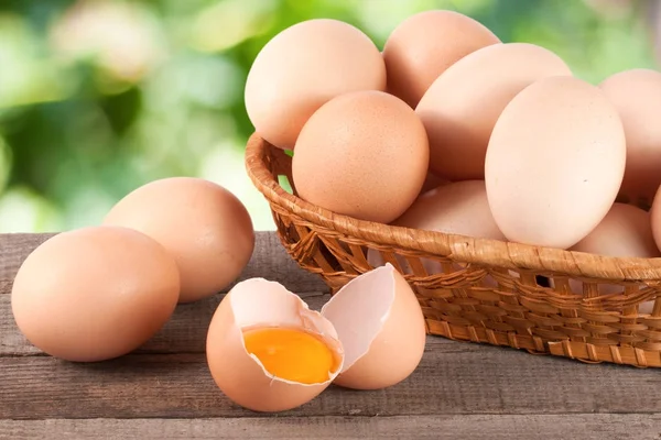 Bahçe arka plan bulanık ile ahşap bir gemide bir hasır sepet yumurta