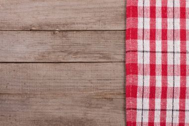Metniniz için kopya alanı ile eski bir ahşap masa üzerinde kırmızı kareli masa örtüsü. Üstten Görünüm