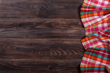 Metniniz için kopya alanı bir koyu ahşap masada kırmızı kareli masa örtüsü. Üstten Görünüm