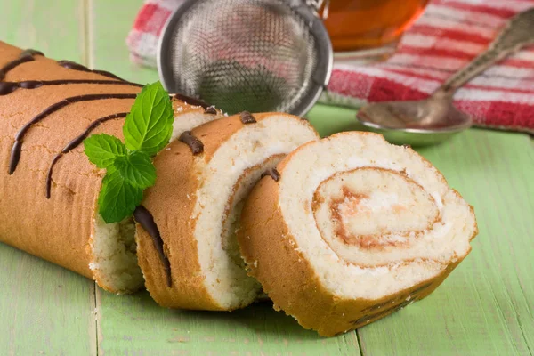 Biscoito suíço rolo no fundo de madeira verde — Fotografia de Stock