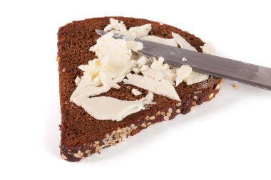 Susam ve beyaz arka plan üzerinde izole tereyağı ile siyah ekmek dilimi